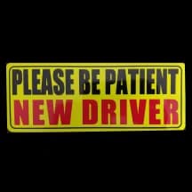 A yellow magnetic car sign reading “Please Be Patient” in black above “New Driver” in red